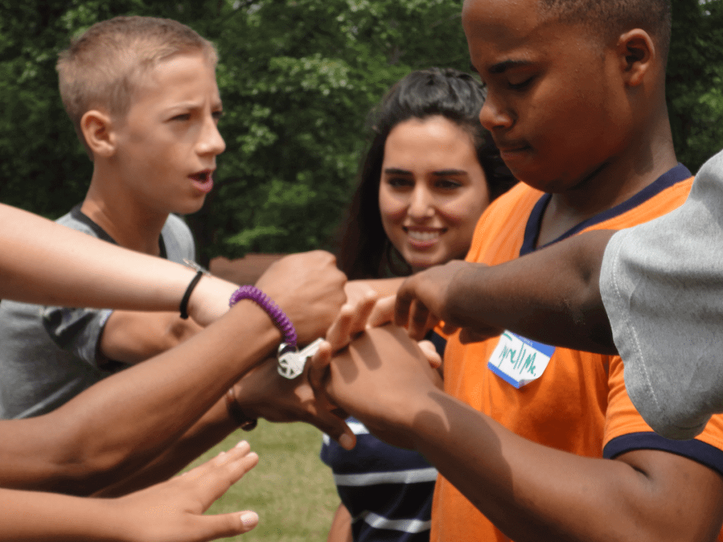 Elijah from Arizona calls "All Hands In" during the Giant Rock, Paper, Scissors game.